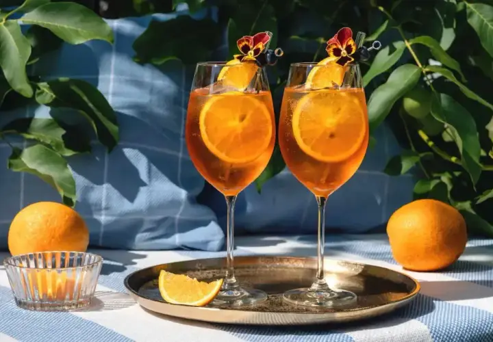 Dwa Aperol Spritz z pomarańczą i kwiatkiem. Idealne na lato, łatwo je zrobić!