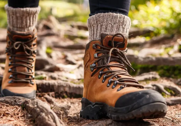 Brown leather hiking boots with thick socks, ready for the trail. Proper wanderschuhe pflegen ensures many adventures.