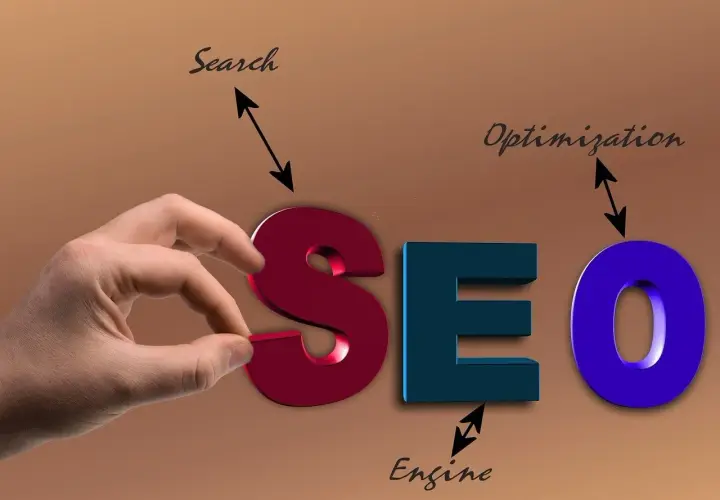 Ręka układa literę "S" w napis SEO, symbolizując usługę optymalizacji dla wyszukiwarek.