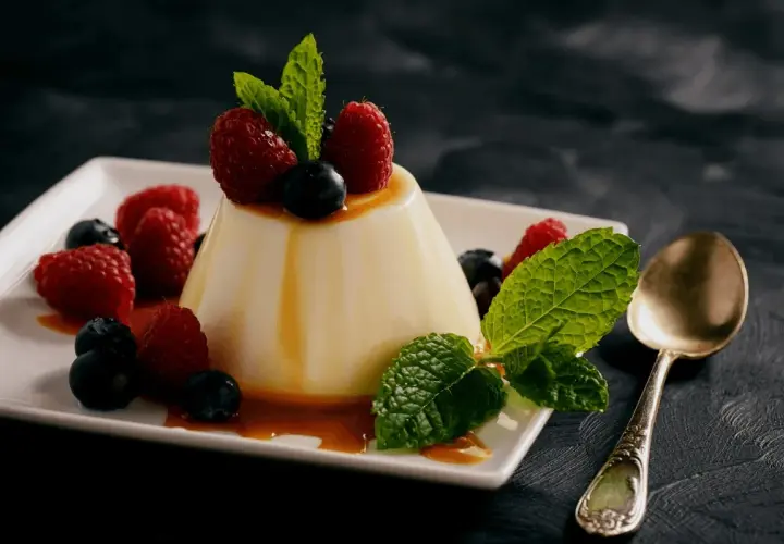 Panna cotta z malinami i borówkami, polana syropem. Idealny deser, gdy szukasz prostego panna cotta przepis.