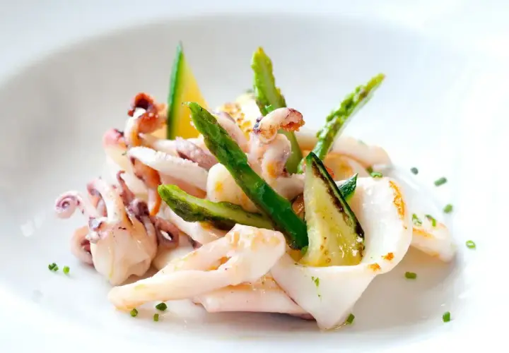 Deliziosa insalata di seppie gourmet con asparagi croccanti e zucchine grigliate, guarnita con erba cipollina.