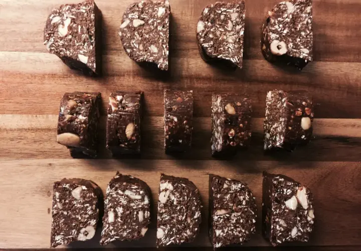 Chokladiga egna bars med nötter och kokos, upplagda på en träskärbräda.