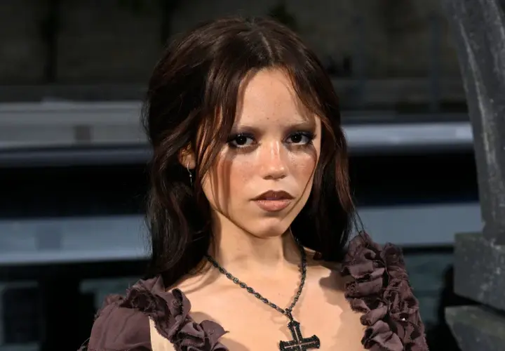 Jenna Ortega, znana z roli Wednesday, ma 160 cm wzrostu. Na zdjęciu ma ciemne włosy i krzyż na szyi.