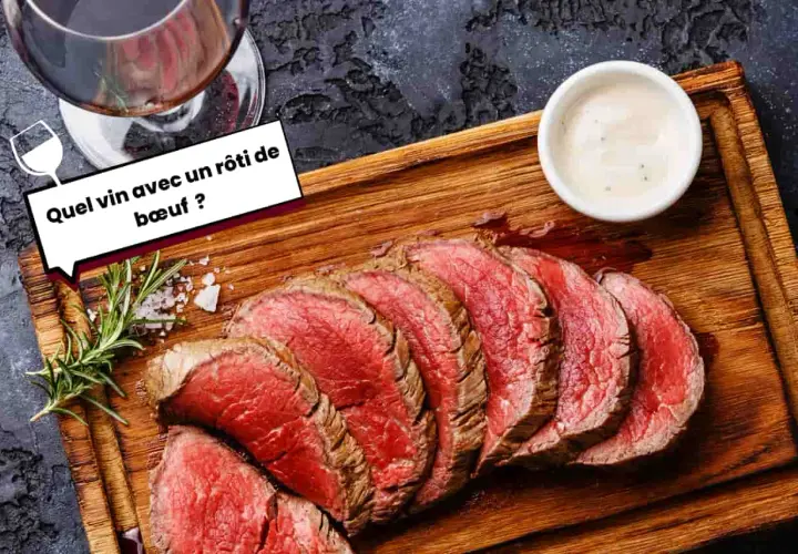 Un verre de vin rouge accompagne un rôti de bœuf tranché, prêt à être dégusté. Une question se pose : quel vin choisir pour ce plat savoureux ?