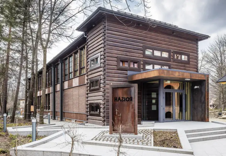 Drewniana, nowoczesna galeria Władysława Hasiora z rustykalnym znakiem wejściowym.
