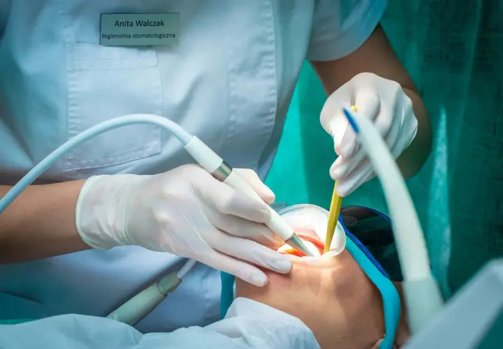 Anita Walczak, higienistka stomatologiczna, dba o zdrowie zębów pacjenta, używając nowoczesnego sprzętu.