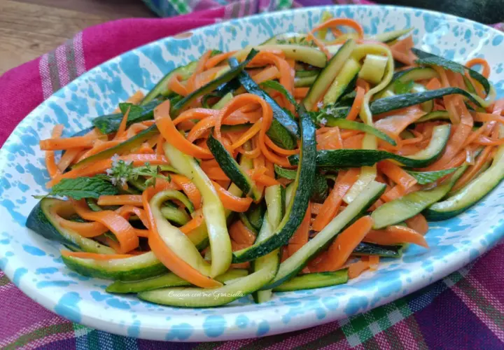 Deliziosa insalata di zucchine e carote a julienne, guarnita con menta fresca. Un piatto leggero e colorato.
