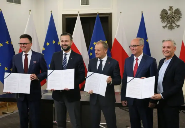 Pięciu mężczyzn w garniturach trzyma dokumenty. To tekst umowy koalicyjnej, symbol porozumienia.