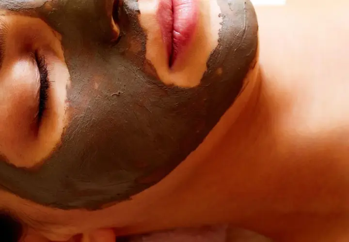 Gesichtsmaske mit Tonerde für **poren reinigen hausmittel**. Eine Frau genießt eine entspannende Gesichtsbehandlung.