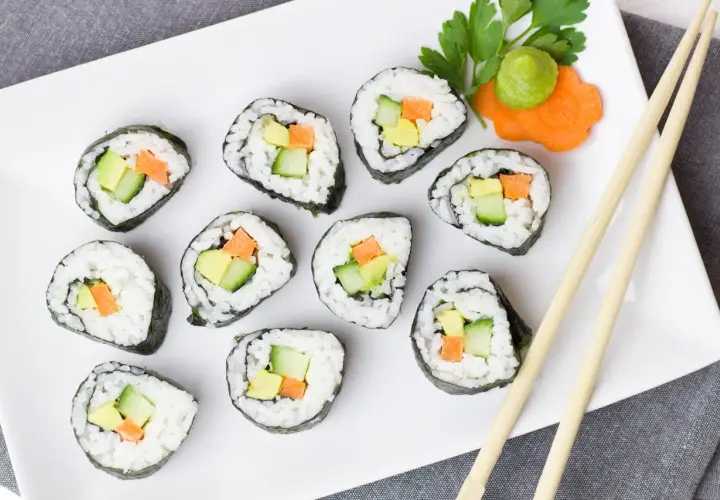 Talerz sushi z awokado, ogórkiem i marchewką. Czy sushi jest kaloryczne? Zależy od składników, ale te warzywne rolki wyglądają lekko!