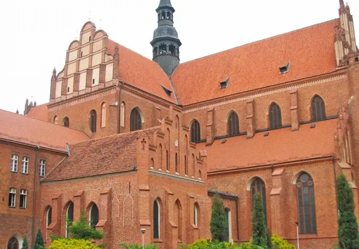 Imponująca ceglana katedra w Pelplinie z charakterystycznymi dachami i wieżą.