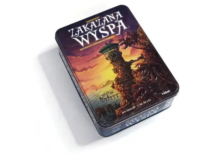 Pudełko gry planszowej "Zakazana Wyspa" z wieżą zegarową i palmami na tle zachodzącego słońca. Przygoda czeka!
