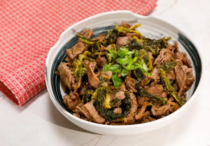 Straccetti di manzo saltati con verdure verdi e guarniti con cipollotto fresco. Un piatto saporito e invitante.