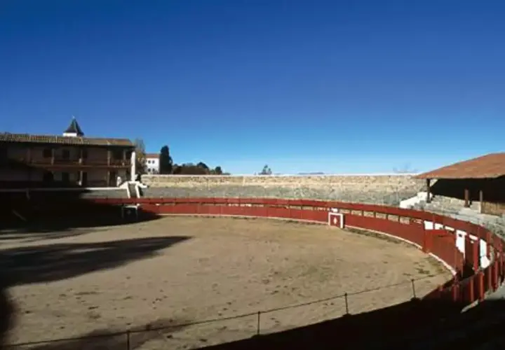 La plaza de toros de Las Ventas, la primera plaza de toros de España, con su ruedo de arena y gradas de piedra bajo un cielo azul.
