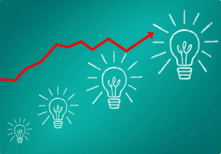 Gráfico de línea roja ascendente sobre bombillas de luz, simbolizando el crecimiento de **herramientas inteligentes** y la innovación.