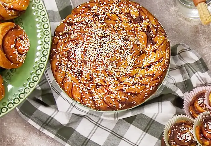 En stor kanelbulle och flera mindre bullar på bakpulver, redo att avnjutas.