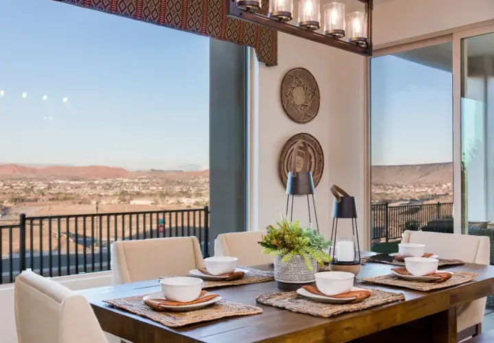 A rustic wooden dining table set for a meal, with a stunning view of a desert landscape. This image inspires how to choose a dining room table for a scenic setting.
