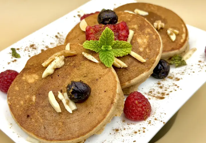 Pancake farina di castagne con lamponi, mirtilli, mandorle e menta. Un dolce autunnale invitante.