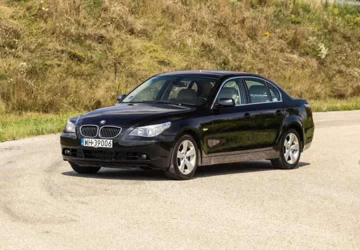 Czarne BMW 535d na tle zielonego wzgórza, gotowe na podróż.
