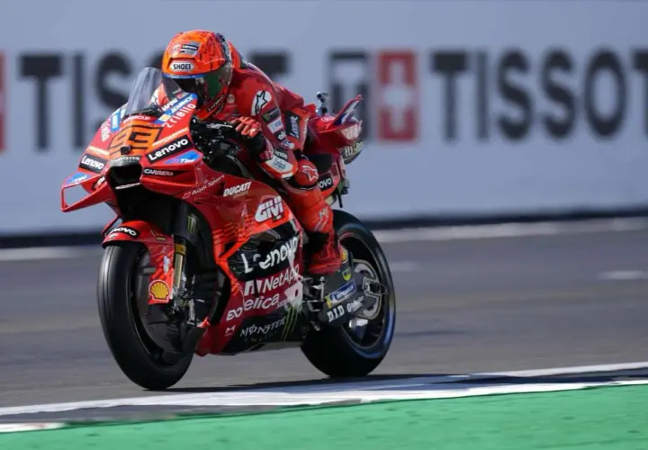 Piloto de Ducati en carrera, con su traje rojo y casco naranja. El número 23 es visible. Mar Márquez compite en la pista.