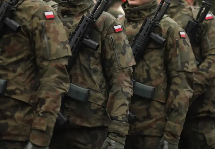 Żołnierze w mundurach moro, z karabinami, gotowi do służby. Każdy z nich, nawet najniższy stopień w wojsku, stanowi ważną część sił zbrojnych.