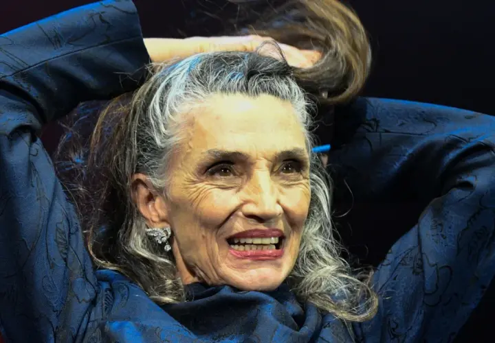 Mujer con peinados pelo largo liso, plateado y castaño, sonriendo y tocándose el cabello con las manos.