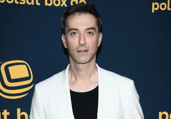 Filip Bobek w białej marynarce i czarnej koszulce, prezentuje się elegancko. Czyżby szykował się na randkę z żoną?