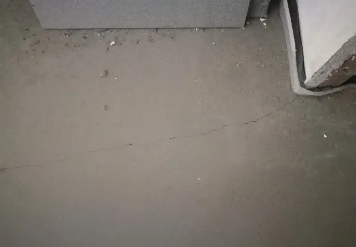 Szara, świeża posadzka z widocznym pęknięciem, przygotowywana do wygrzewania.
