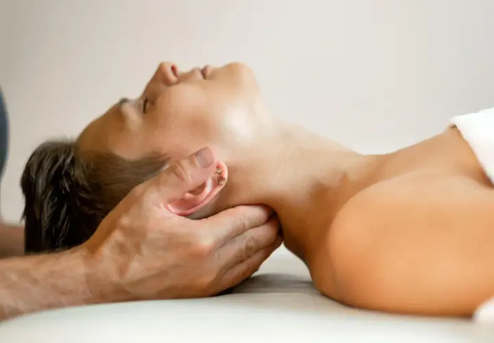 Halsmassage bei einer Osteopathie-Behandlung. Die Dauer einer osteopathie behandlung variiert.