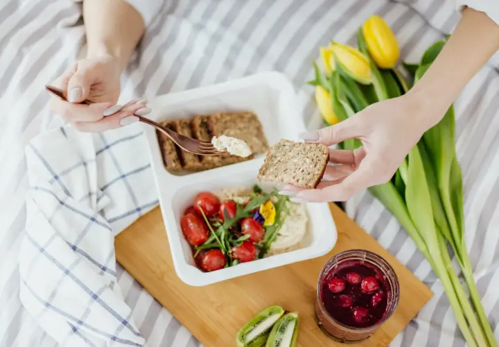 Zdrowy posiłek: pełnoziarniste pieczywo, hummus, pomidorki i owoce leśne. Idealne, by dowiedzieć się, co jeść na zaparcia.