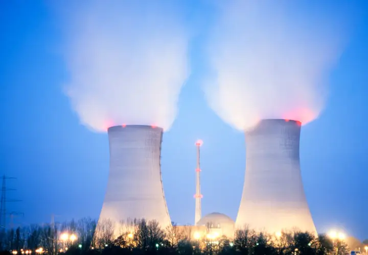 Dwie chłodnie kominowe elektrowni atomowej w Polsce wydzielają parę. W tle widać kopułę reaktora i wieżę.
