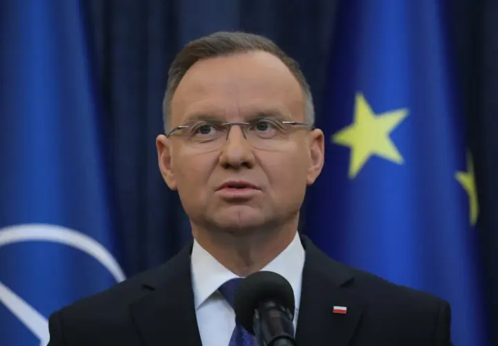 Prezydent Andrzej Duda, mimo nacisków własnej partii, odmówił ułaskawienia znanych polityków. Na zdjęciu widać go na tle flag UE i NATO.