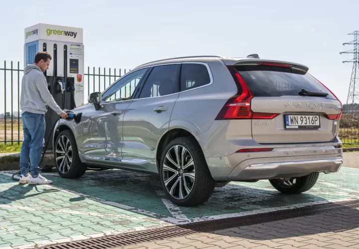 Mężczyzna ładuje Volvo XC60, nowoczesną turbo hybrydę, na stacji Greenway.