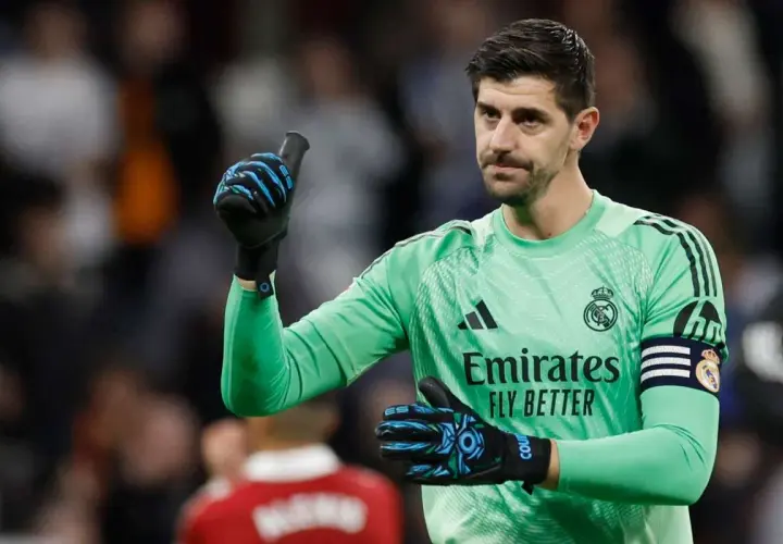 Thibaut Courtois, jeden z kapitanów Realu Madryt, w zielonej koszulce bramkarskiej, pokazuje kciuk w górę.