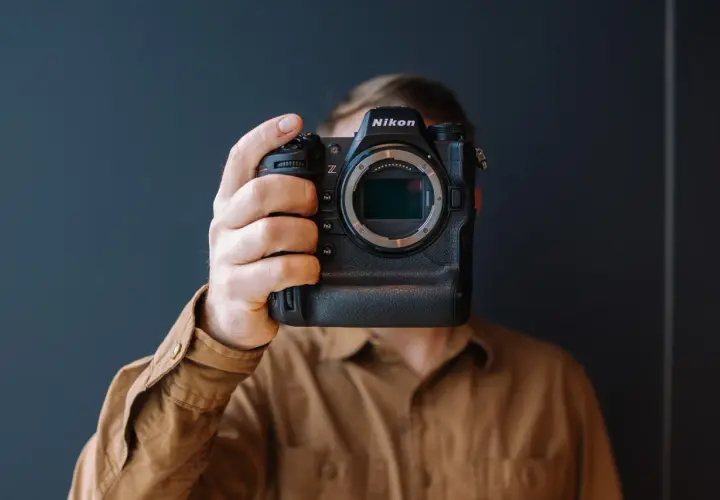 Osoba trzyma aparat Nikon Z9, zasłaniając twarz. Trwa test tego profesjonalnego sprzętu.