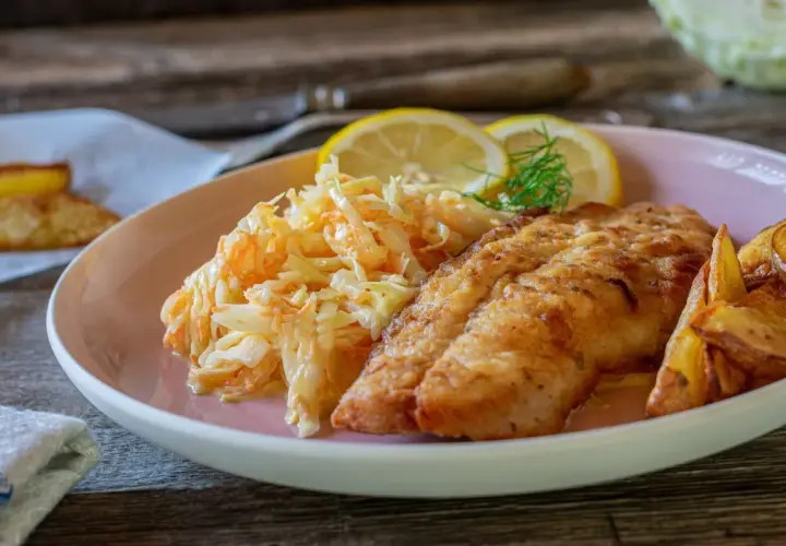 Chrupiący filet rybny z ziemniakami i świeżą surówką do ryby.