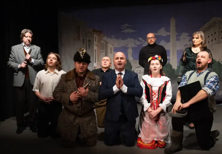 Aktorzy na scenie, w strojach z epoki, tworzą teatr ciut frapujący. W tle malowana miejska panorama.