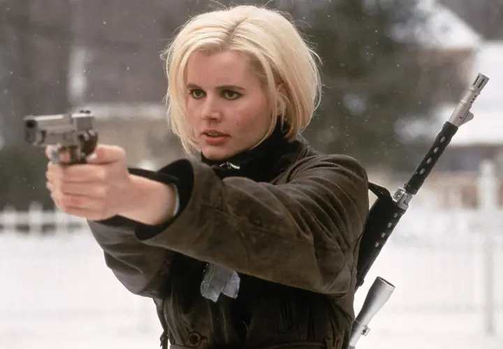 Geena Davis w filmach akcji, z pistoletem w dłoni i karabinem na ramieniu, gotowa do akcji w zimowej scenerii.