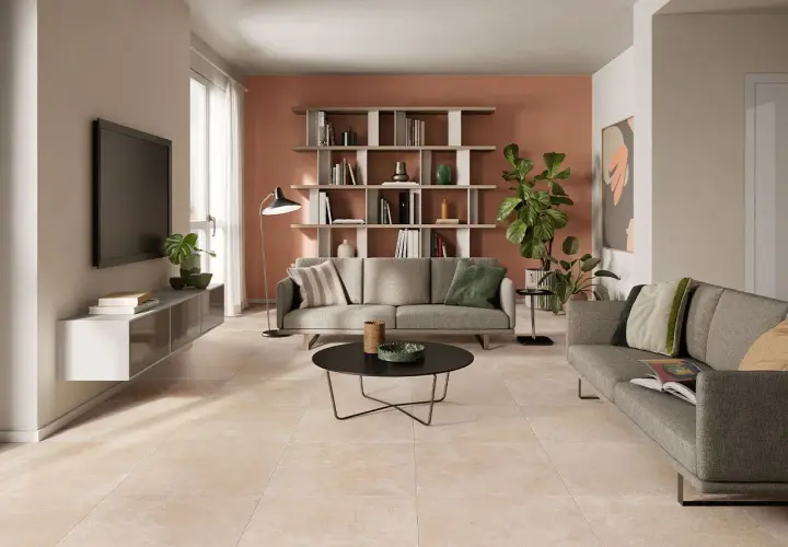 Soggiorno moderno con divani grigi, libreria e un elegante pavimento effetto cemento abbinamento perfetto con l'arredo.