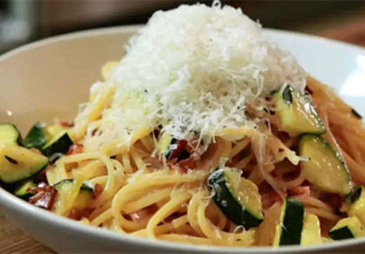 Spaghetti mit Zucchini und Speck, gekrönt mit frisch geriebenem Parmesan. Eine köstliche Zucchini Carbonara.