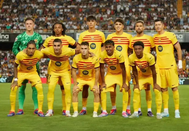 Drużyna FC Barcelona w żółtych strojach, z kapitanem na czele, gotowa do gry.
