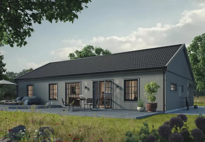 Grått trähus med altan och utemöbler. En cykel står parkerad. Tänk på vad kostar det att bygga ut huset för att få mer plats.