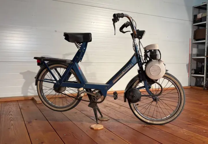 Velosolex antigua azul, un clásico de dos ruedas con motor, lista para revivir viejas aventuras.