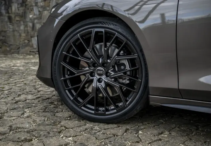 Błyszczące, czarne felgi Audi z homologacją opon Michelin Pilot Sport 5 na kamiennej nawierzchni.