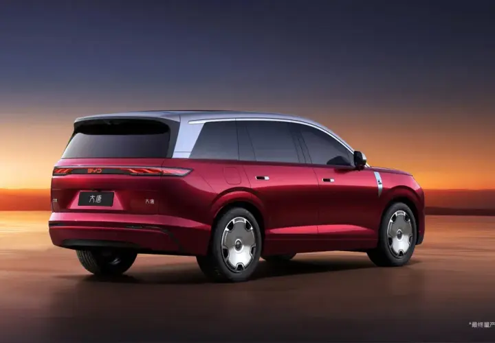 Czerwony elektryczny SUV BYD Tang z dwukolorowym nadwoziem na tle zachodzącego słońca.