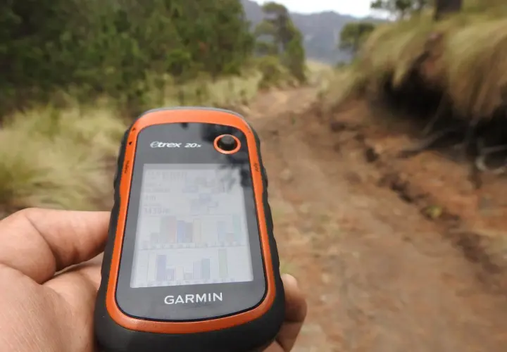 Ręka trzyma GPS Garmin Etrex 20x, idealny do poszukiwań w terenie. To właśnie dzięki takim urządzeniom odkrywasz, geocaching co to jest i jak działa.