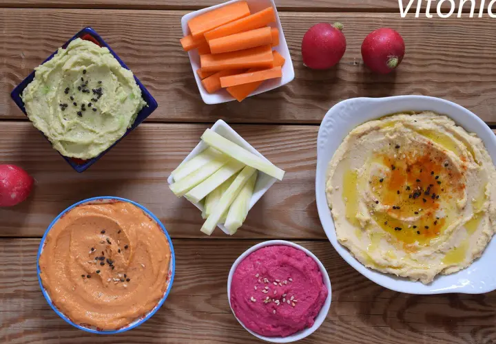 Variedad de hummus, zanahorias, apio y rábanos. Ideas para recetas de hummus saludables y deliciosas.