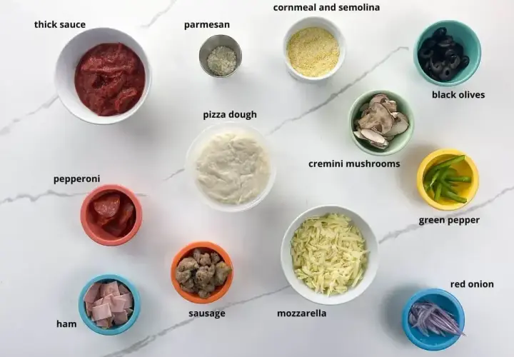 Składniki na pizzę: ciasto, sos, ser, pieczarki, salami, szynka, kiełbasa, oliwki, papryka, cebula. Pieczarki do pizzy są już pokrojone.