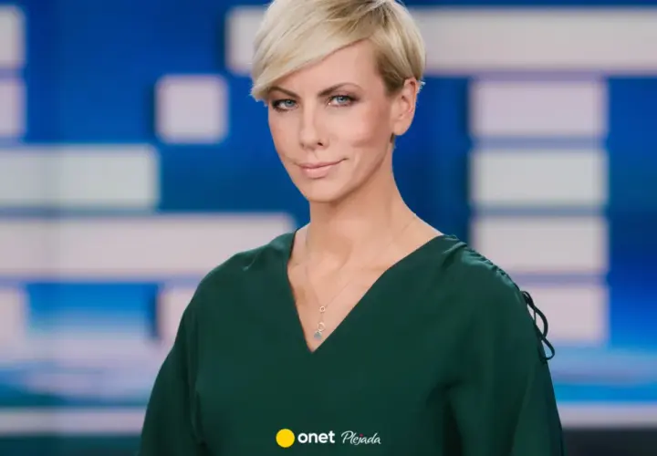 Anita Werner w zielonej sukience, z krótkimi blond włosami, na tle niebiesko-białej grafiki.