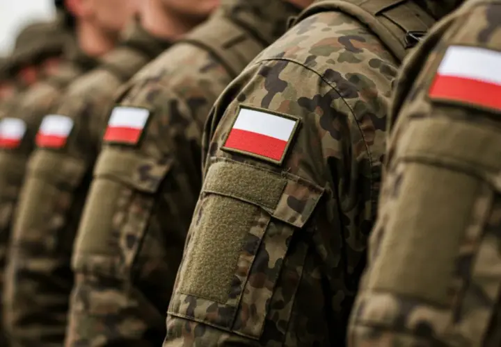 Żołnierze w mundurach moro z polskimi flagami na ramionach, gotowi na wezwania do wojska.